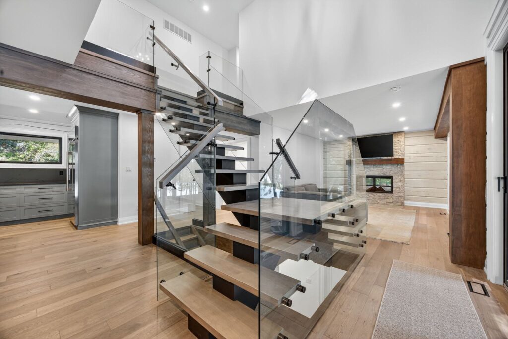 The custom glass staircase of a log home renovated by Legacy North Construction Management. 